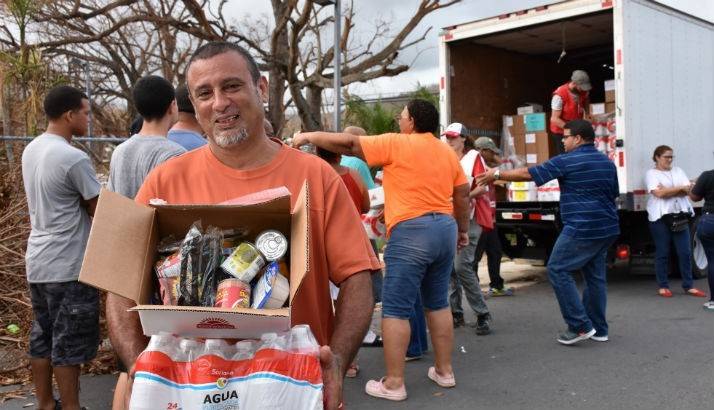 Red Cross volunteers distribute water, food and other basic necessities to families affected by Hurricane Maria.