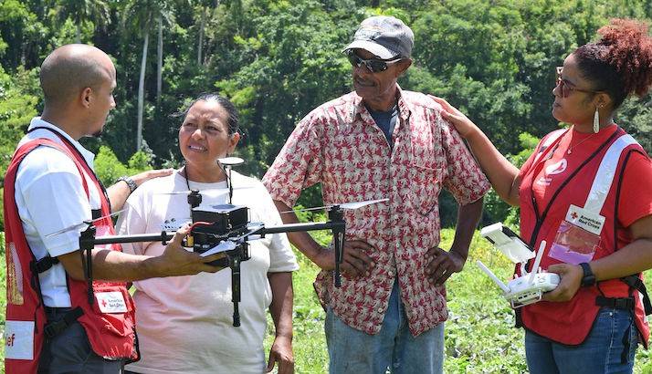 Carmen Umpierre and Carlos Cruz talk with Red Cross workers, Humberto Román and Iris Medero about the drone assessment.