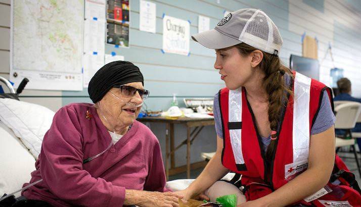 Volunteer Maddy Thoresen checks on Glen Leotta, 93, and her dog, Sally, at the Sonoma Fairgrounds shelter. 