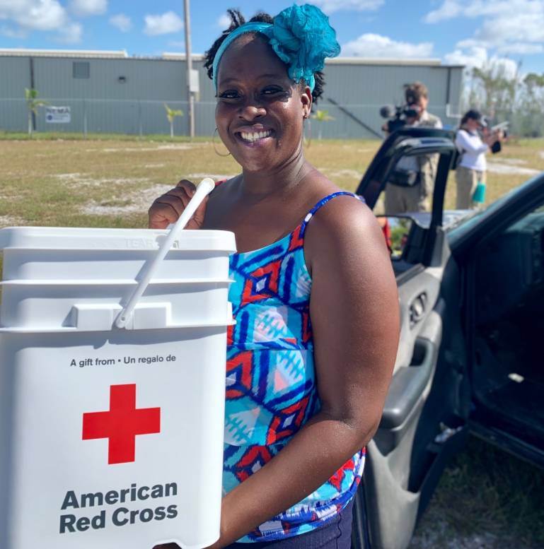 Carmel picks up supplies from a Red Cross supply distribution in her neighborhood.