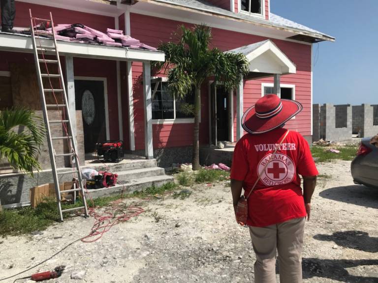 Bahamas Red Cross Community Mobilizer Lauren Riviere checks in on one of the homes given financial assistance for repairs.