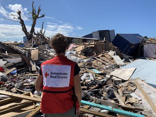 A Red Cross volunteer surveying the disaster damage.
