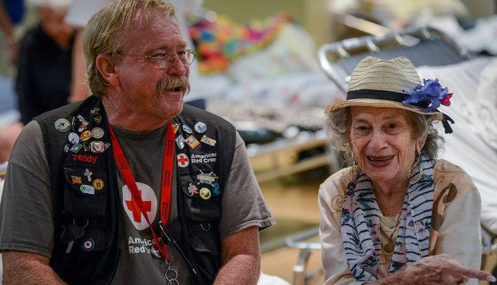 American Red Cross volunteer Teddy Rhamy shares a few minutes with Philomena DeNardo, a 91-year-old shelter resident at the St Cloud Senior Center. 