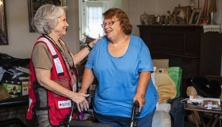 Lettie Craig talking to a Red Cross volunteer in her home.
