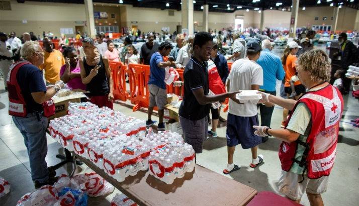Red Cross volunteers handing out lunches to people at the shelter.