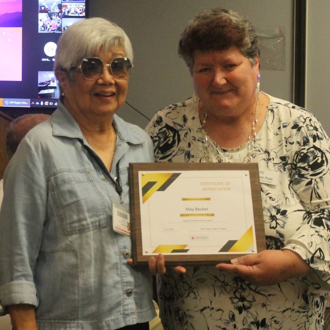 may becker and susan pope holding volunteer of the year certificate