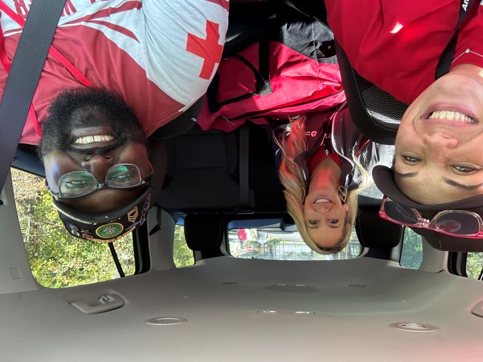 three red cross volunteers in a car