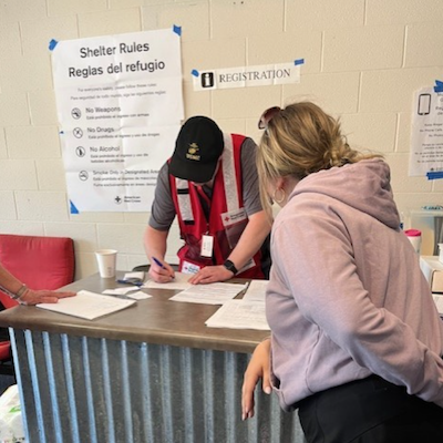 Red Cross volunteer registering a client at a disaster shelter
