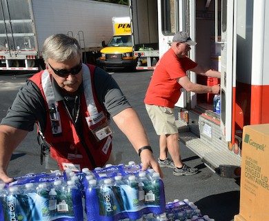 Red Cross volunteers unloading water bottles from Red Cross vehicle